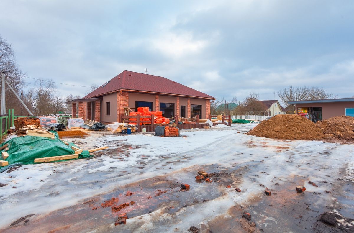 The modern house with terrace is under construction (remodel) and construction material for renovation are outside